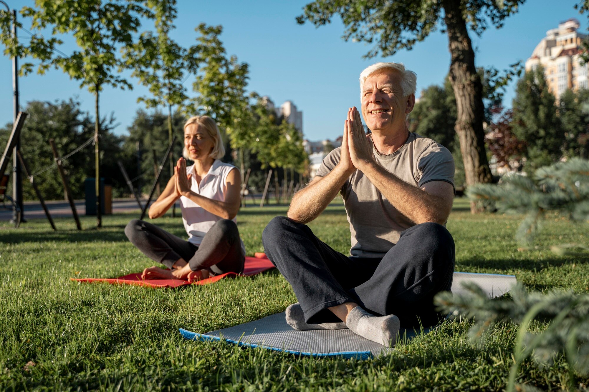 Persona mayor practicando yoga suave al aire libre al amanecer